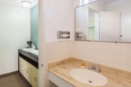 a bathroom with a sink and a mirror at Days Inn by Wyndham Camarillo - Ventura in Camarillo