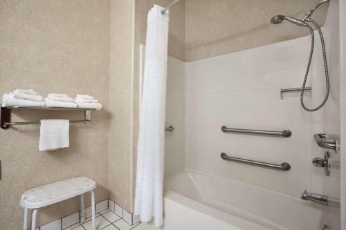 Days Inn by Wyndham Columbia Mall في غراند فوركس: حمام مع دش وحوض استحمام ومرحاض