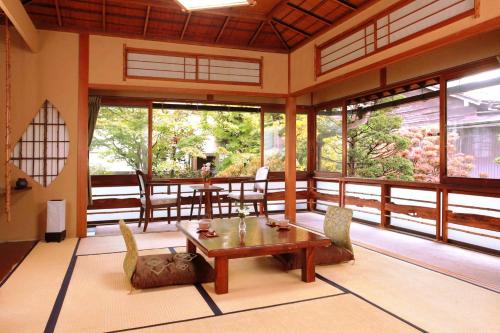 a living room with a wooden table and chairs at Ryokan Kaminaka in Takayama