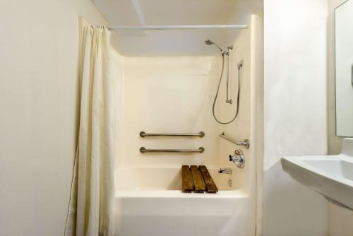 y baño blanco con ducha y bañera. en Days Inn by Wyndham Pontoon Beach, en Pontoon Beach