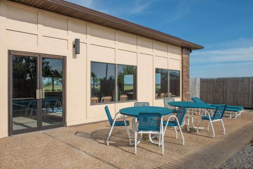 a group of tables and chairs outside of a building at Days Inn by Wyndham Pontoon Beach in Pontoon Beach