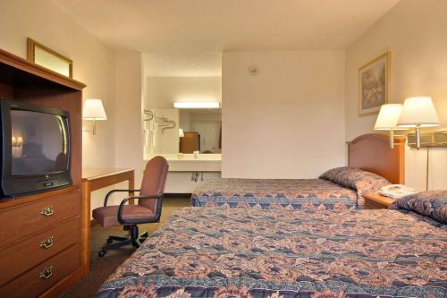 a hotel room with two beds and a television at Days Inn by Wyndham Plainfield in Plainfield