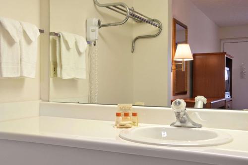 a bathroom with a sink and a mirror at Days Inn by Wyndham Plainfield in Plainfield