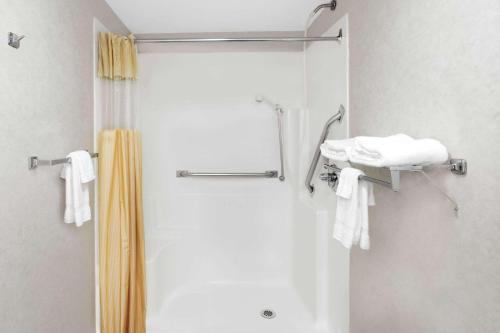 a shower with a yellow shower curtain and towels at Days Inn by Wyndham Morristown in Morristown