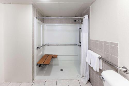 a bathroom with a shower with a bench in it at Days Inn by Wyndham Oklahoma City Fairground in Oklahoma City