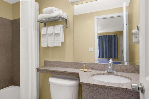 bagno con lavandino, servizi igienici e specchio di Days Inn by Wyndham Middletown a New Hampton
