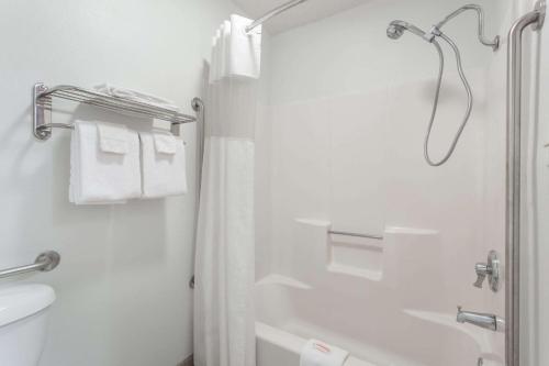 a white bathroom with a shower and a toilet at Days Inn by Wyndham Colby in Colby