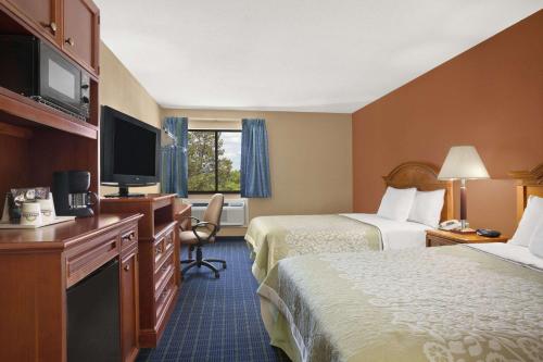 a hotel room with two beds and a flat screen tv at Days Inn by Wyndham Middletown in New Hampton