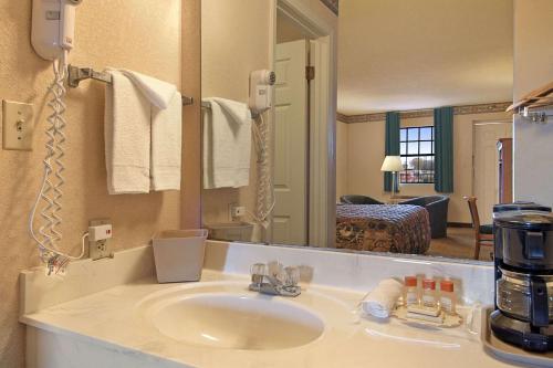 baño con lavabo y espejo grande en Days Inn by Wyndham Brownsville, en Brownsville