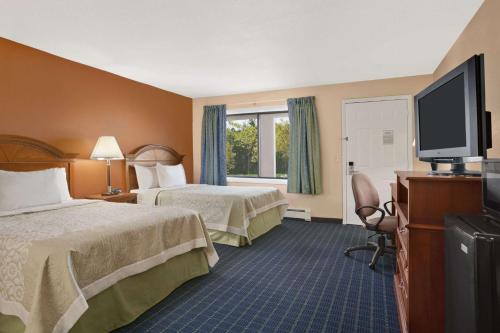 a hotel room with two beds and a flat screen tv at Days Inn by Wyndham Middletown in New Hampton