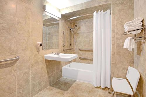 y baño con bañera, lavamanos y ducha. en Days Inn by Wyndham Parsippany, en Parsippany