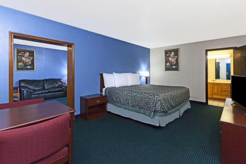 a hotel room with a bed and a couch at Days Inn by Wyndham Oklahoma City Fairground in Oklahoma City