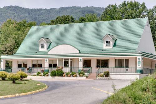 a large house with a green roof at Days Inn by Wyndham Asheville West in Candler
