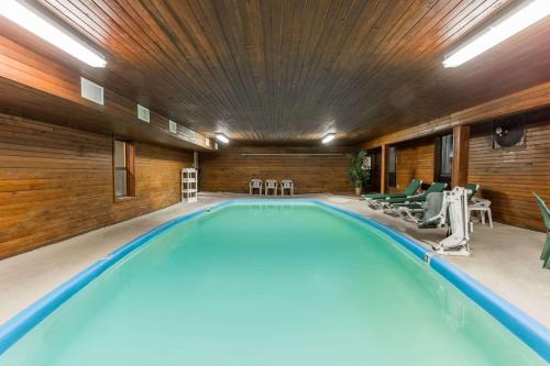 een groot zwembad met stoelen en een plafond bij Days Inn by Wyndham Colby in Colby