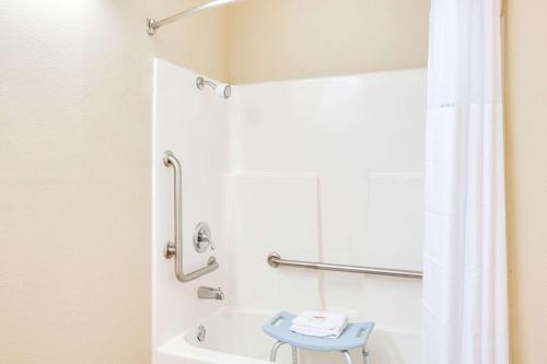 a bathroom with a shower and a blue stool at Days Inn by Wyndham Newport in Newport