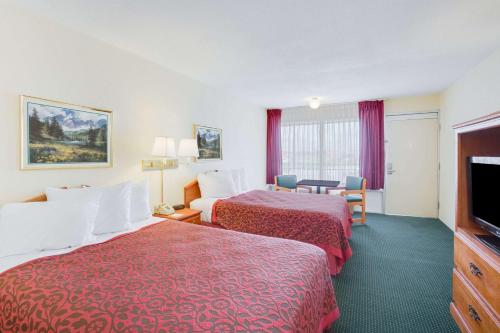 a hotel room with two beds and a flat screen tv at Days Inn by Wyndham Newport in Newport