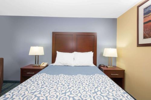 a bed in a hotel room with two lamps at Days Inn by Wyndham Grand Island in Grand Island