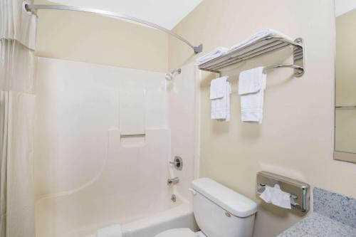 a white bathroom with a toilet and a shower at Days Inn by Wyndham Grand Island in Grand Island