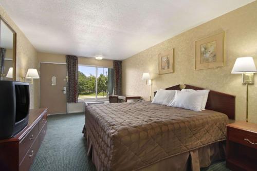 a hotel room with two beds and a television at Days Inn by Wyndham Roanoke Civic Center in Roanoke