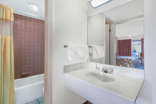 een witte badkamer met een wastafel en een spiegel bij Days Inn by Wyndham Mt. Sterling in Mount Sterling