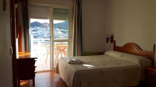 a bedroom with a bed and a large window at Las Olas in San José