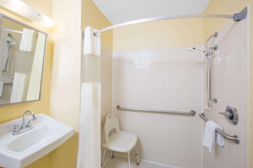 a white bathroom with a sink and a shower at Days Inn by Wyndham Grand Island in Grand Island