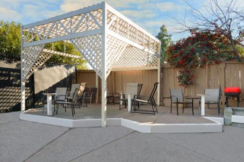 a pergola with chairs and tables on a patio at Days Inn by Wyndham Pinole Berkeley in Pinole