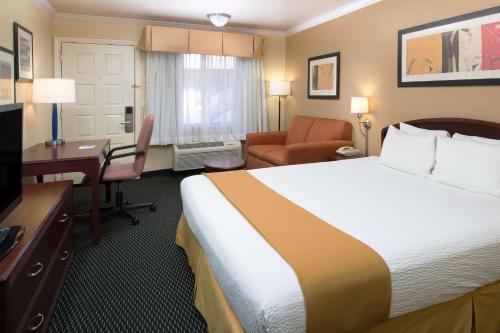 a hotel room with a bed and a desk at Days Inn by Wyndham Pinole Berkeley in Pinole