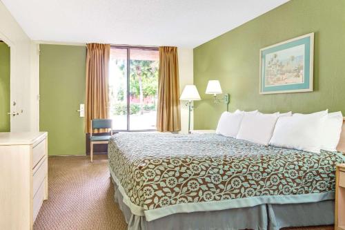a hotel room with a bed and a window at Days Inn by Wyndham Bradenton - Near the Gulf in Bradenton