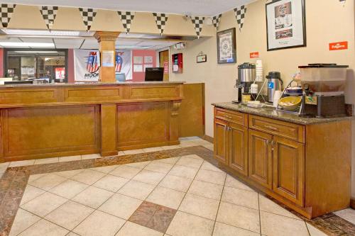 a kitchen with wooden cabinets and a counter in a restaurant at Days Inn by Wyndham Mooresville Lake Norman in Mooresville