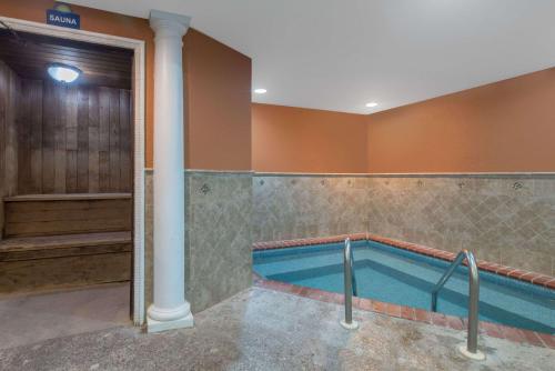 a bathroom with a tub and a pool at Days Inn by Wyndham Minot in Minot
