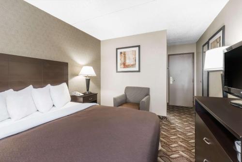a hotel room with a bed and a television at Days Inn by Wyndham Bismarck in Bismarck