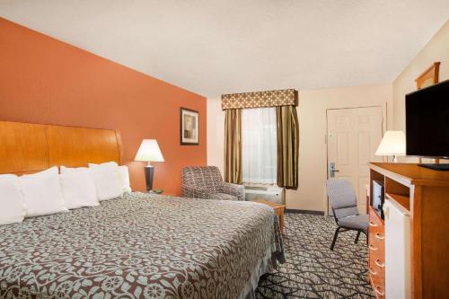 a hotel room with a bed and a flat screen tv at Days Inn by Wyndham Centerville in Centerville