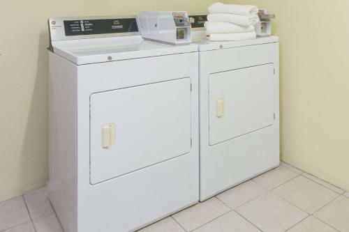 
a white refrigerator sitting next to a white sink at Days Inn by Wyndham Wilkes Barre in Wilkes-Barre
