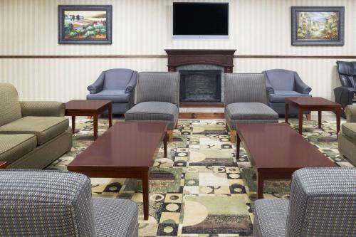 a waiting room with couches and chairs and a fireplace at Days Inn by Wyndham Columbus-North Fort Moore in Columbus