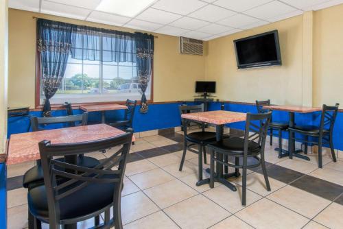a restaurant with tables and chairs and a tv at Days Inn by Wyndham Great Bend in Great Bend
