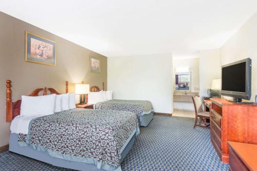 a hotel room with two beds and a flat screen tv at Days Inn by Wyndham Arlington Pentagon in Arlington