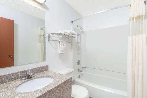 a bathroom with a sink and a tub and a toilet at Days Inn by Wyndham Great Bend in Great Bend