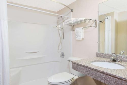 a bathroom with a toilet and a sink and a shower at Days Inn by Wyndham Great Bend in Great Bend