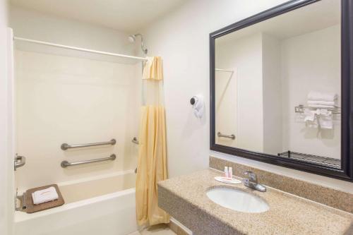 a bathroom with a sink and a mirror at Days Inn by Wyndham Tucson Airport in Tucson