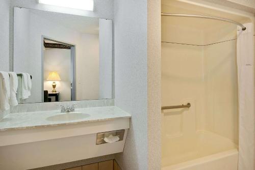 La salle de bains est pourvue d'un lavabo, d'un miroir et d'une douche. dans l'établissement Days Inn by Wyndham Lisbon, à Lisbon