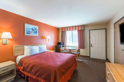 a hotel room with a large bed and a desk at Days Inn by Wyndham Tucson Airport in Tucson