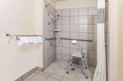 łazienka z prysznicem z krzesłem w obiekcie Days Inn by Wyndham Imlay City w mieście Imlay City
