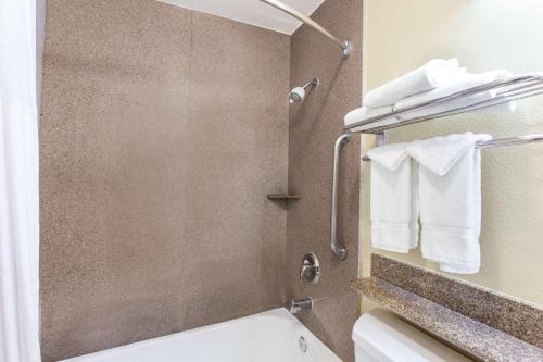 a bathroom with a shower with a toilet and towels at Days Inn by Wyndham Carlsbad in Carlsbad