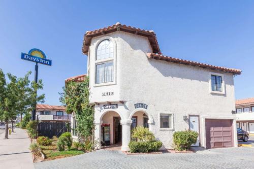 a white building with a street sign in front of it at Days Inn by Wyndham Castaic Six Flags Magic Mountain in Castaic