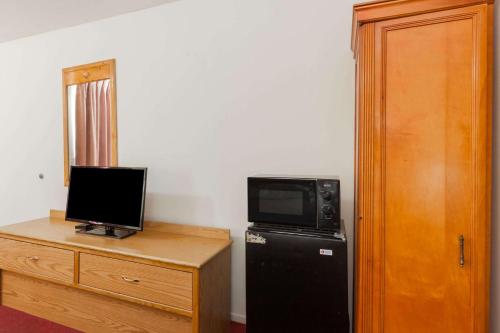 a room with a refrigerator and a microwave and a television at Days Inn by Wyndham Castaic Six Flags Magic Mountain in Castaic