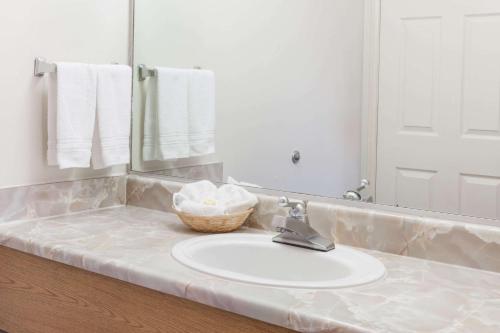 La salle de bains est pourvue d'un lavabo et d'un miroir. dans l'établissement Days Inn by Wyndham Castaic Six Flags Magic Mountain, à Castaic