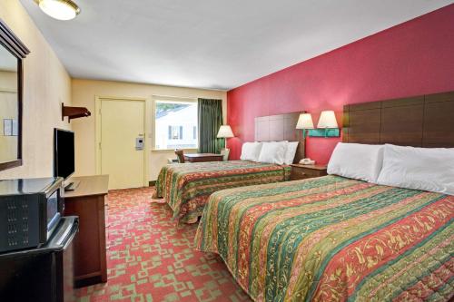 ein Hotelzimmer mit 2 Betten und einem Flachbild-TV in der Unterkunft Days Inn by Wyndham Elizabeth City in Elizabeth City