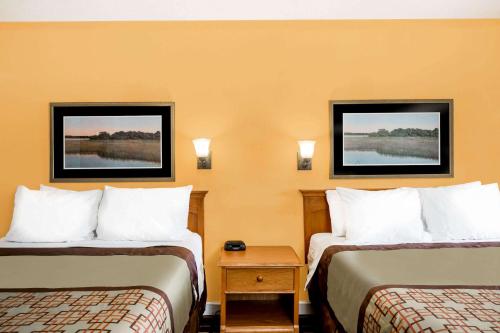 a hotel room with two beds and two pictures on the wall at Days Inn by Wyndham Little River in Little River