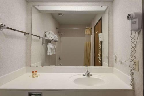 baño con lavabo y espejo grande en Days Inn by Wyndham Jefferson City en Jefferson City